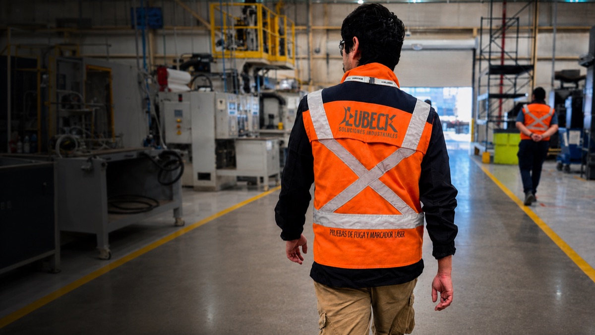 Técnico Lübeck caminando en piso de planta, uniforme de marca Lübeck